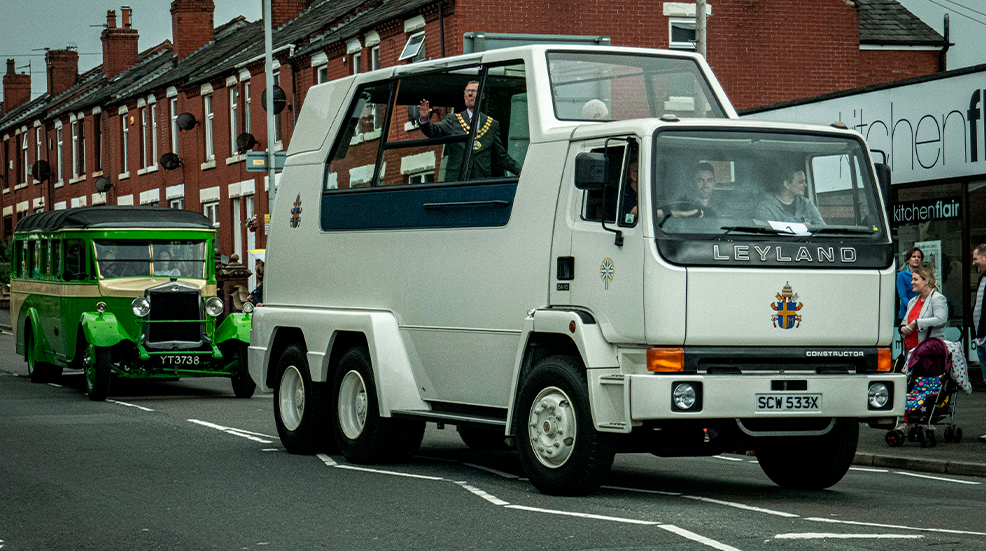 A Leyland-built Popemobile going down a public road during a parade